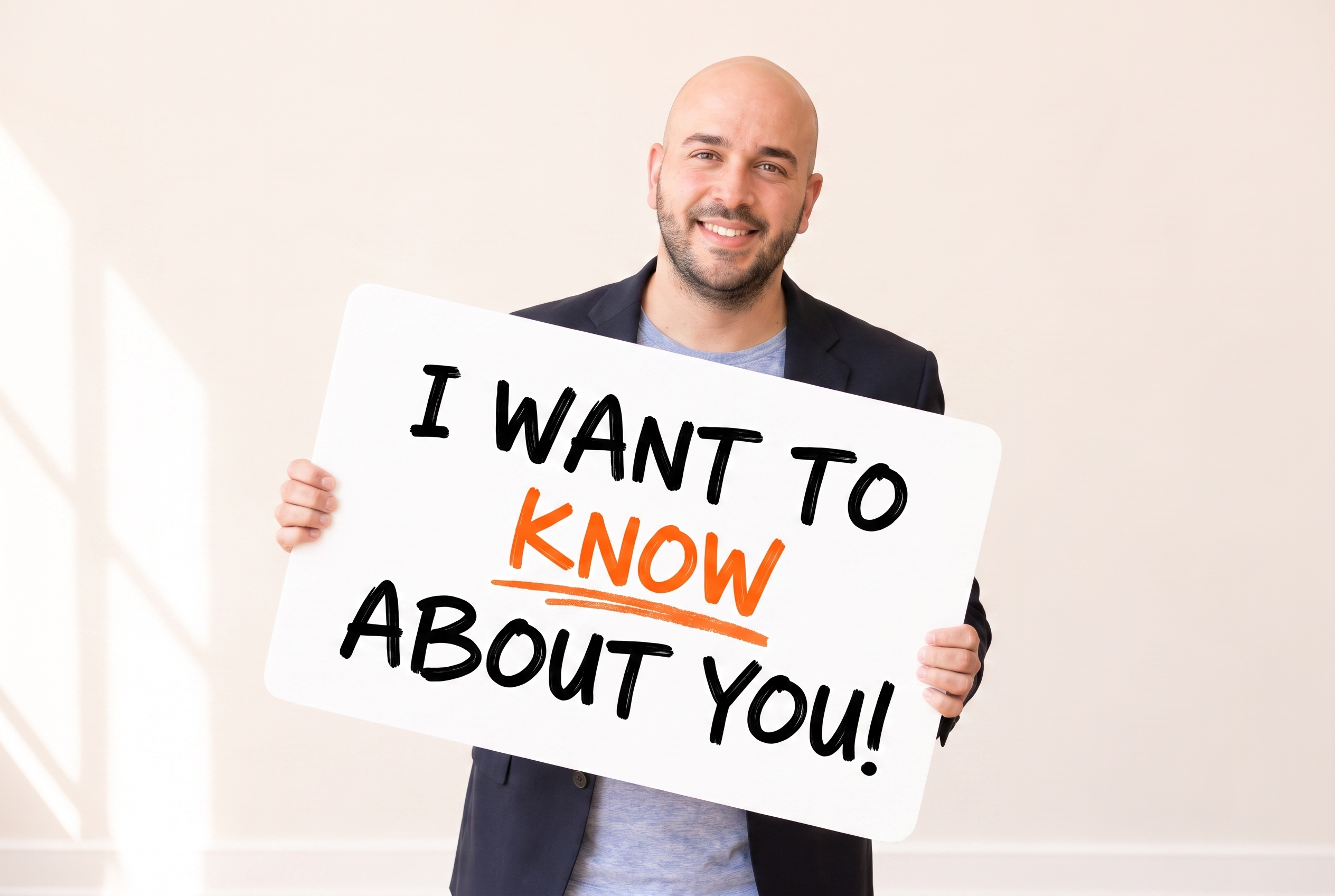 Jonny West holding a sign that reads: I want to KNOW about you!